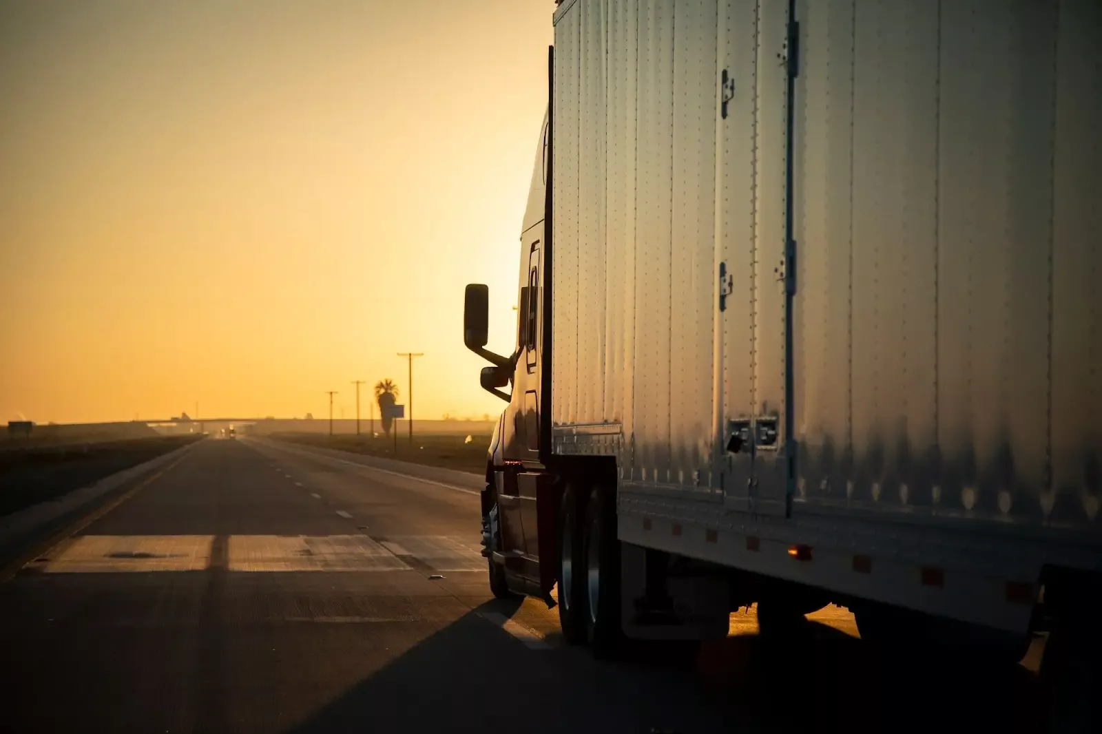 commercial truck driving off into the sunset